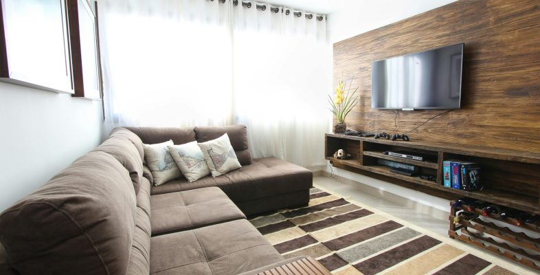 Stylish modern living room featuring a brown sofa, wall-mounted TV, and interior decor.